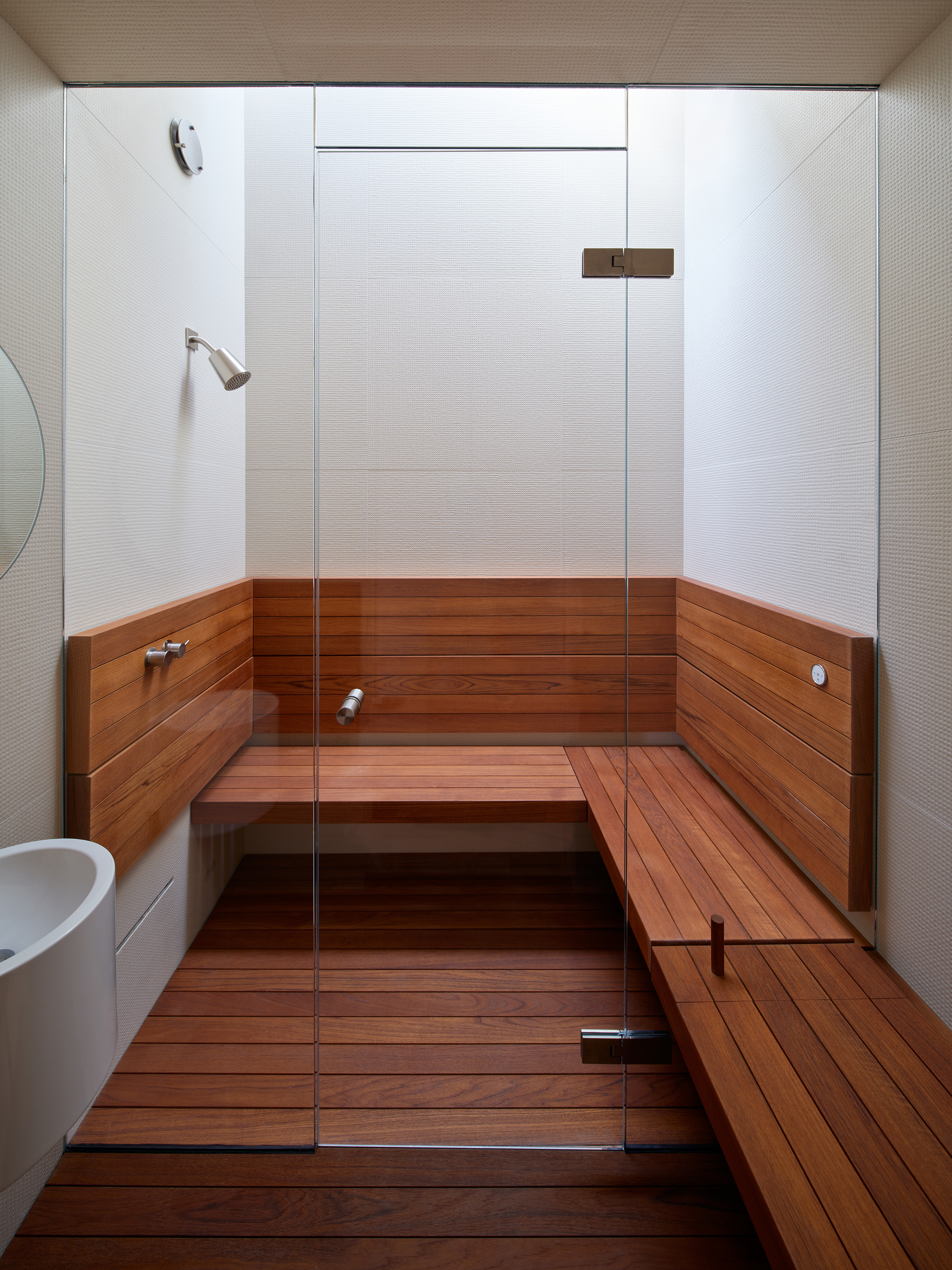 View of built in wood seating in the shower and skylight above